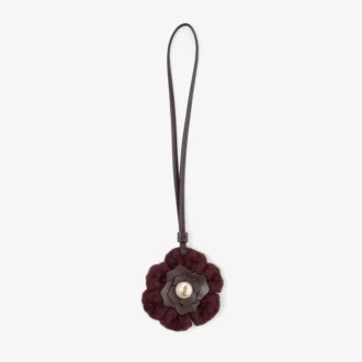 Gestrickter Blumenanhänger Gestrickter Blumenanhänger aus tiefem Merlot-farbener Wolle mit Lederbesatz